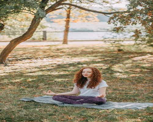Woman meditating yoga outdoors sunlight